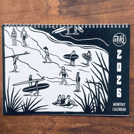 2026 monthly calendar with black and white illustrations of people and surfboards on a wooden surface