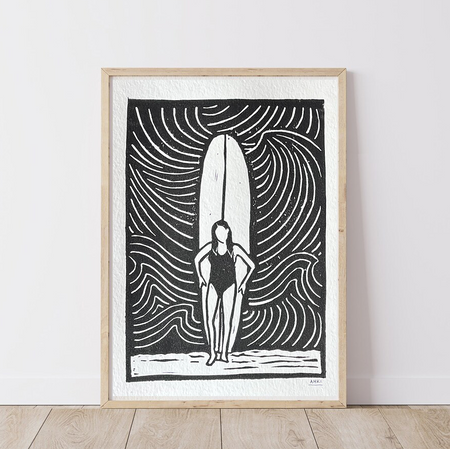 Framed Artwork of a girl standing in front of her longboard surfboard, with ocean wave patterns in the background