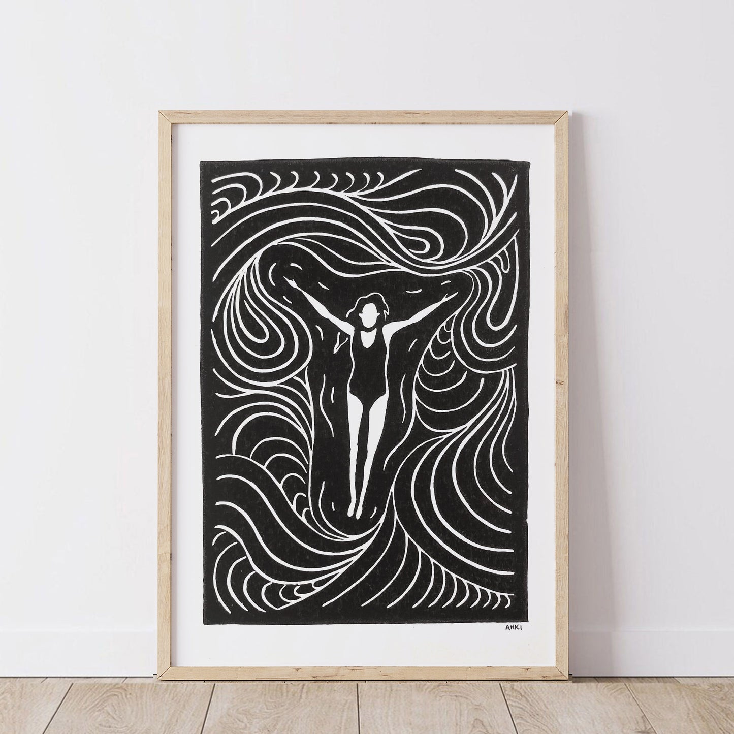 Framed black and white artwork of a woman with floating in the ocean with flowing lines of movement