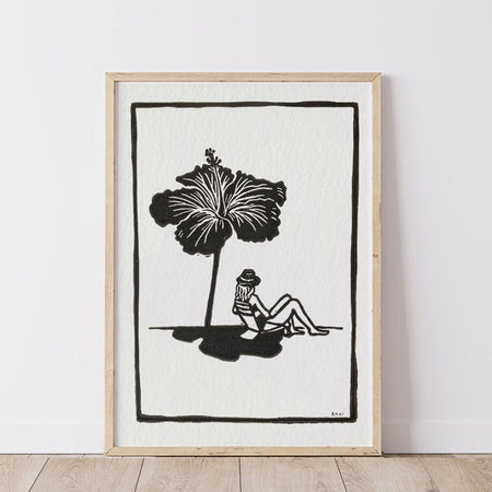 Framed artwork of a woman sun baking  under a hibiscus flower as an umbrella shade