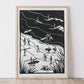 Framed artwork with black and white illustrations of people by a beach on a white wall. Beach scene with surfboards