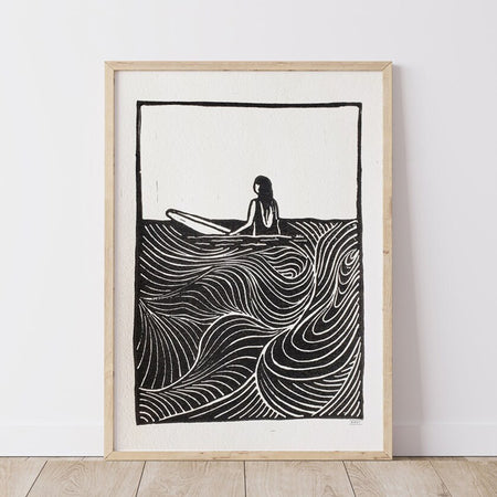 Surfer girl art lino print of a girl sitting out in the ocean on her surfboard with wave lines and textures
