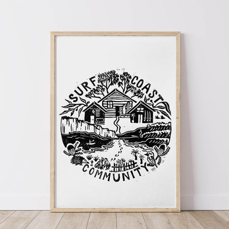 Framed artwork with a black and white illustration of a coastal scene and Surf Coast Community