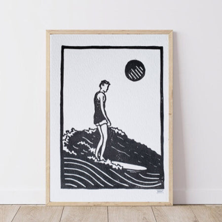 Framed black and white artwork of a person on a wave with a minimalistic design.